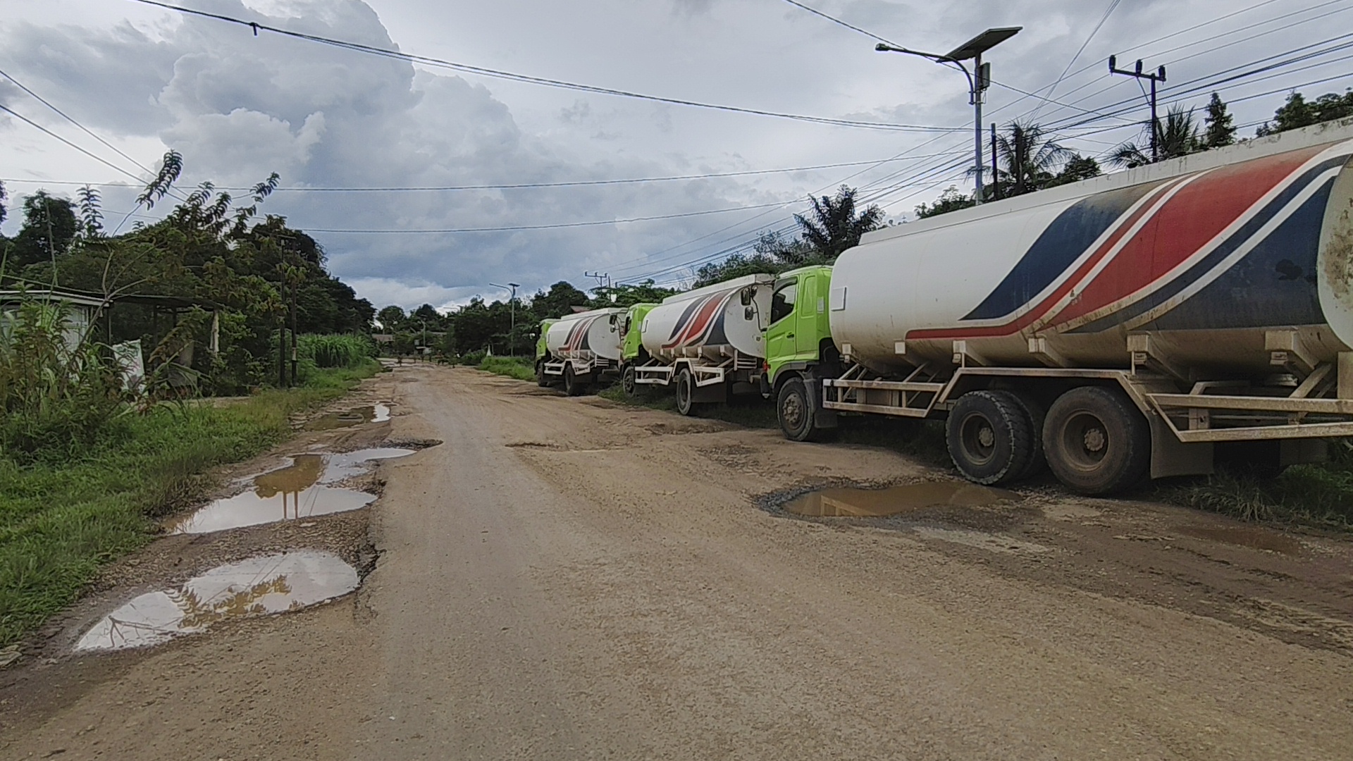 Belasan unit truk CPO parkir lantaran dilarang warga melintas karena jalan rusak