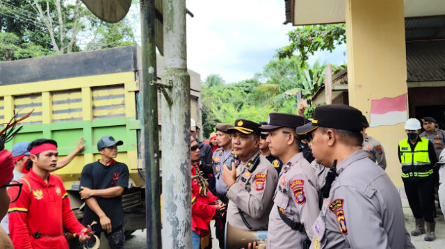 Kepala Bagian Operasi (Kabag Ops) Polres Kutai Barat, KOMPOL Emanuel Teguh Budi Santoso, S.T., memberikan arahan kepada peserta aksi damai yang tergabung dalam Tariu Borneo Bangkule Rajakng (TBBR) di kawasan Site Bunyut PT Trubaindo Coal Mining, Kecamatan Melak, Jumat (19/6/2026). Aparat kepolisian melakukan pendekatan persuasif guna menjaga situasi tetap aman dan kondusif selama berlangsungnya aksi. Foto: Johansyah