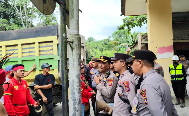 Kepala Bagian Operasi (Kabag Ops) Polres Kutai Barat, KOMPOL Emanuel Teguh Budi Santoso, S.T., memberikan arahan kepada peserta aksi damai yang tergabung dalam Tariu Borneo Bangkule Rajakng (TBBR) di kawasan Site Bunyut PT Trubaindo Coal Mining, Kecamatan Melak, Jumat (19/6/2026). Aparat kepolisian melakukan pendekatan persuasif guna menjaga situasi tetap aman dan kondusif selama berlangsungnya aksi. Foto: Johansyah